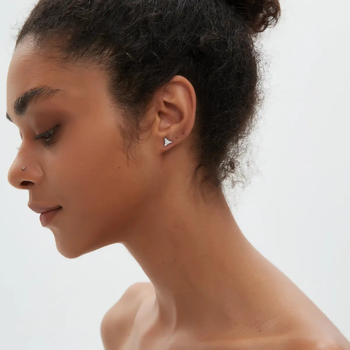 Model wearing the Diamond Star Stud from the Celestial Reverie collection. The sculptural geometric star silhouette and natural diamonds create cinematic celestial brilliance, architectural elegance, and contemporary editorial luxury jewelry styling.