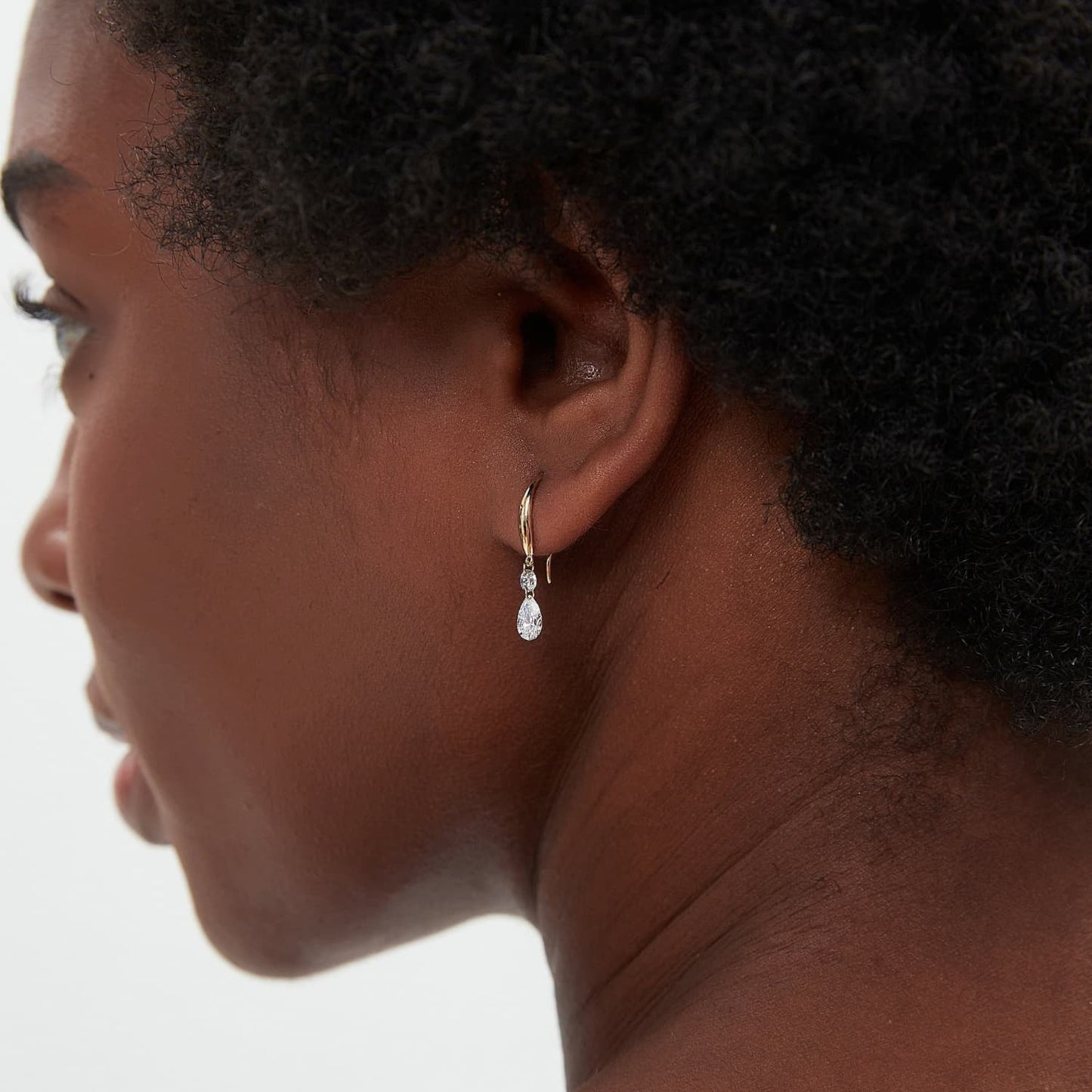 A fashion editorial shot featuring the White Pear Round Dangle Hoop. Showcases the refined silhouette and cinematic radiance of the piece as a modern heirloom, reflecting the LTM Jewels aesthetic of sustainable luxury.