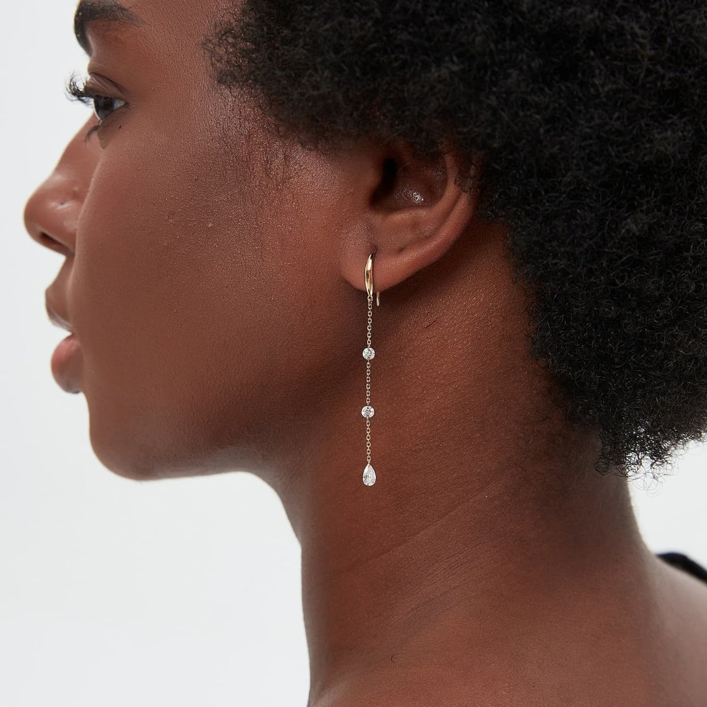 An editorial fashion image featuring the Triple Diamond Chain Dangle Hoop. Captures the balanced brilliance and modern luxury aesthetic of the piece as a cinematic heirloom from the Radiant Drift collection.