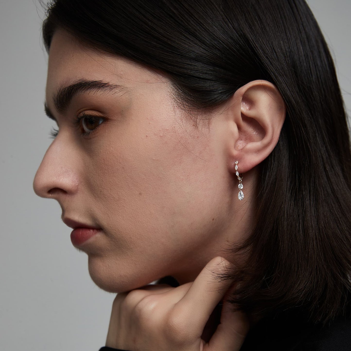 On-ear styling of a luxury mixed-cut diamond dangle hoop for evening wear