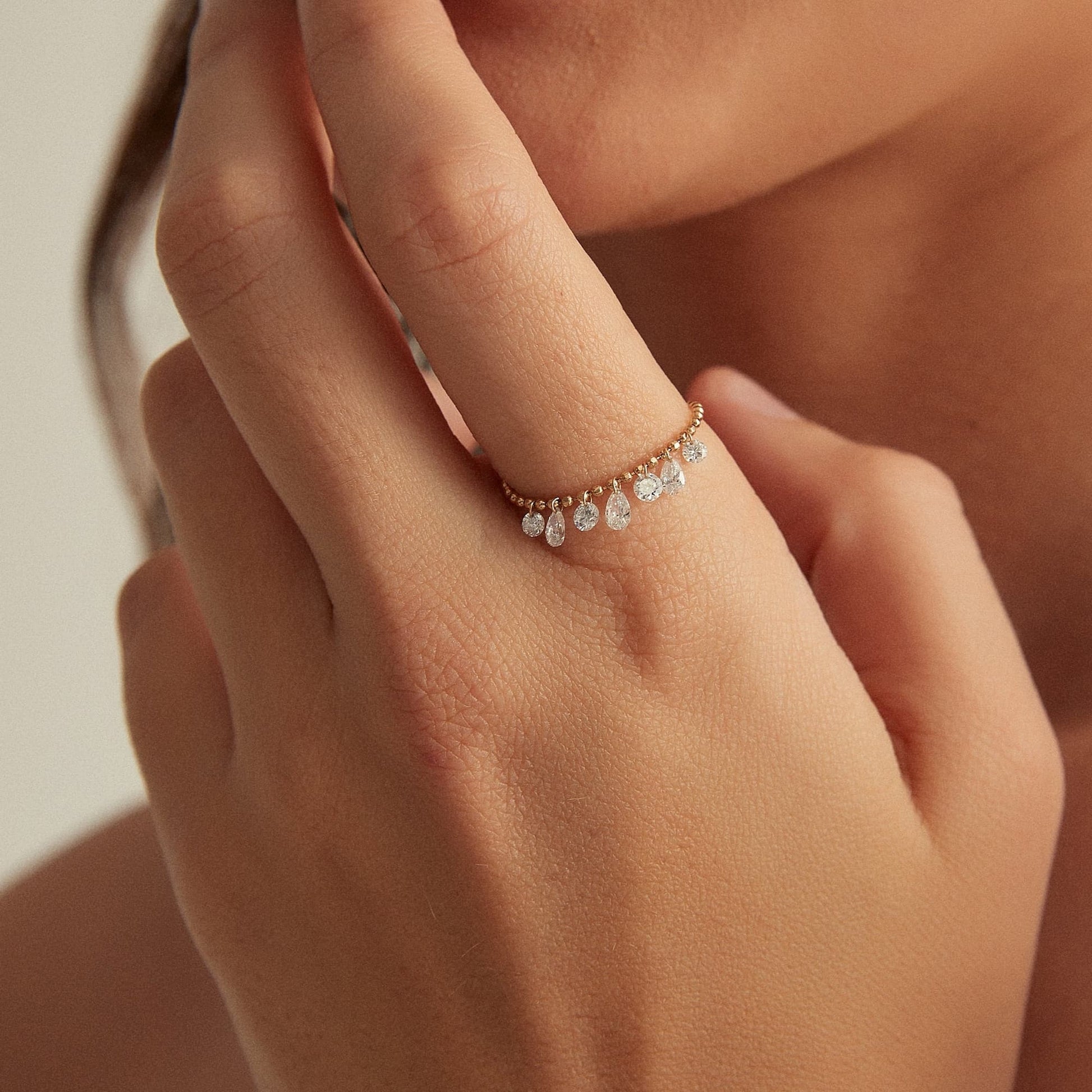On-finger styling of a luxury bead chain ring stack featuring 7 dangling diamonds
