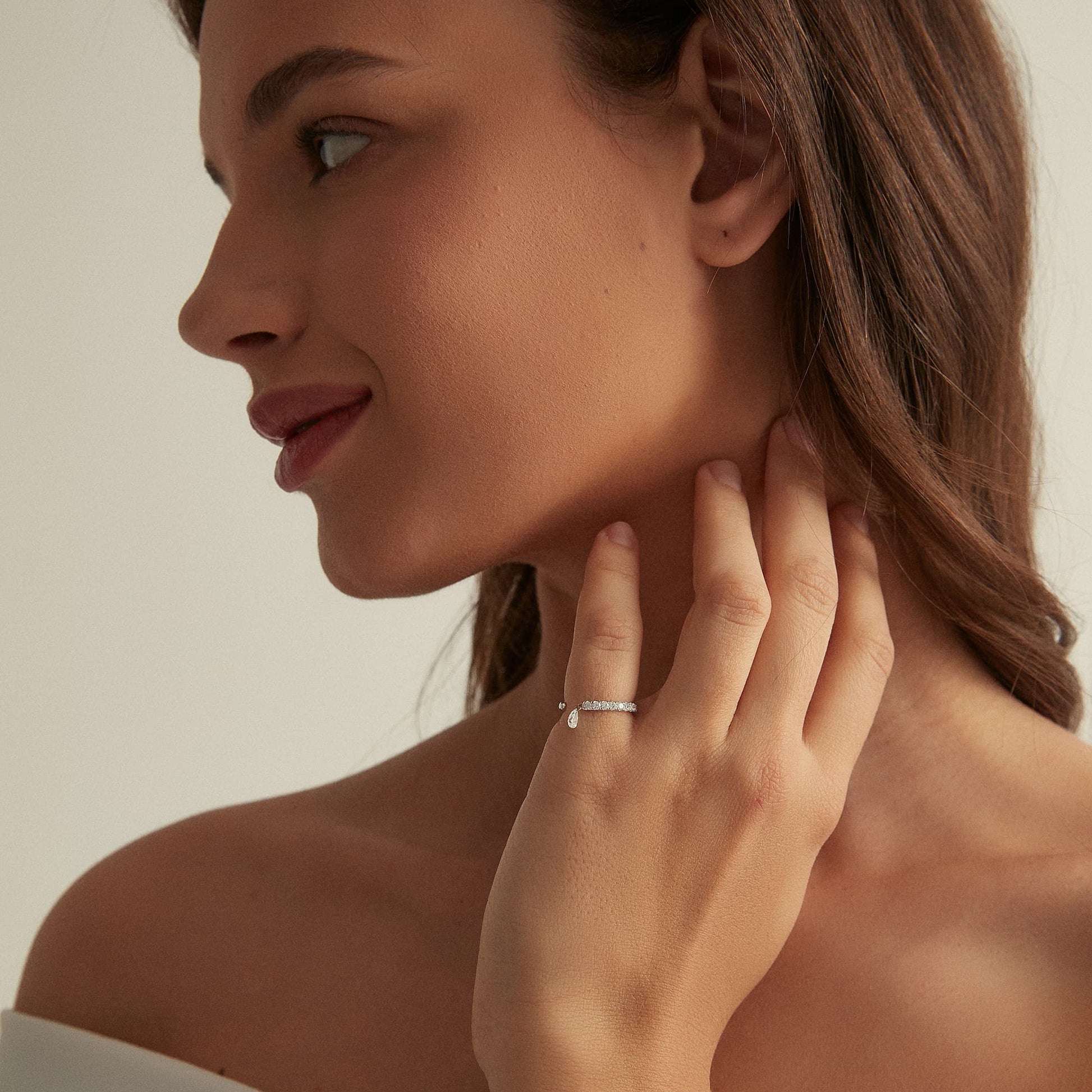 Side view showing the fluid movement of the dangling pear diamond on the ring