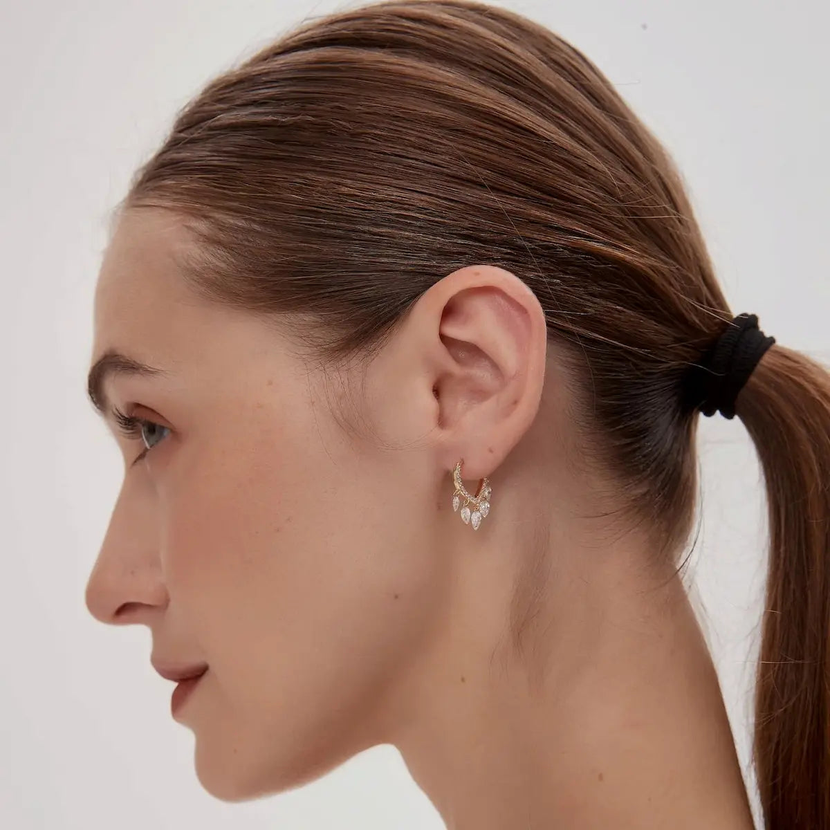 Side profile and detached view of the 18K gold heart dangle hoop, focusing on the secure hinged clicker closure and the easy-to-use detachable mechanism. This perspective confirms the high-polish finish of the solid gold and the slim, architectural silhouette of the heart frame. Designed for 24/7 permanent wear, the side view highlights the snag-free construction and professional-grade quality of LTM Jewels' signature designs, perfect for side sleepers and active lifestyles.