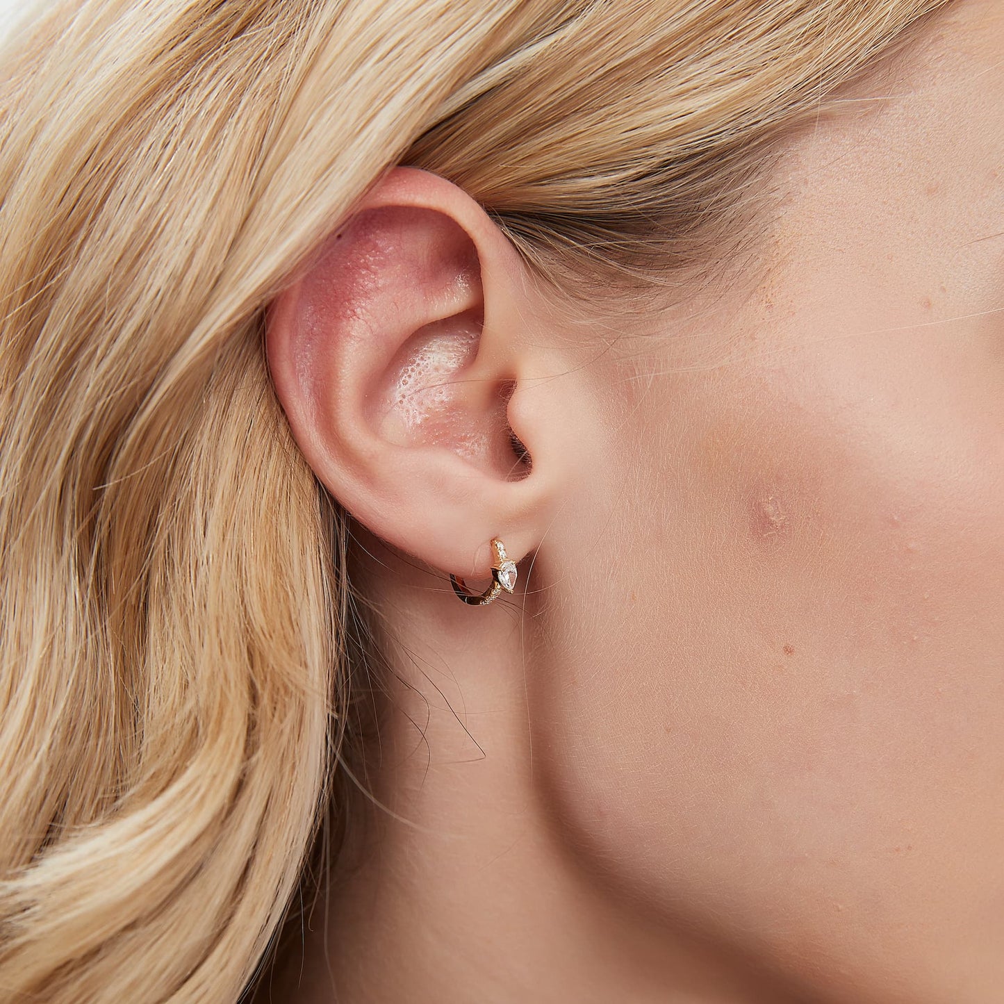 A technical side profile view of the Pear Pavé Hoop. This image highlights the structural integrity of the 18K solid gold AU750 construction and the seamless integrated hinge closure engineered for a secure 24/7 fit. The side perspective showcases the 8mm diameter and the slim, comfortable profile of the pavé-set diamonds, ensuring a flush and elegant fit against the lobe or helix. The consistent high-polish finish and the alignment of the 0.183ctw diamonds are clearly visible.