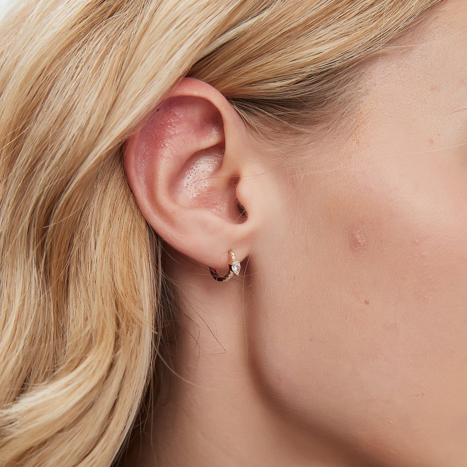 A technical side profile view of the Pear Pavé Hoop. This image highlights the structural integrity of the 18K solid gold AU750 construction and the seamless integrated hinge closure engineered for a secure 24/7 fit. The side perspective showcases the 8mm diameter and the slim, comfortable profile of the pavé-set diamonds, ensuring a flush and elegant fit against the lobe or helix. The consistent high-polish finish and the alignment of the 0.183ctw diamonds are clearly visible.