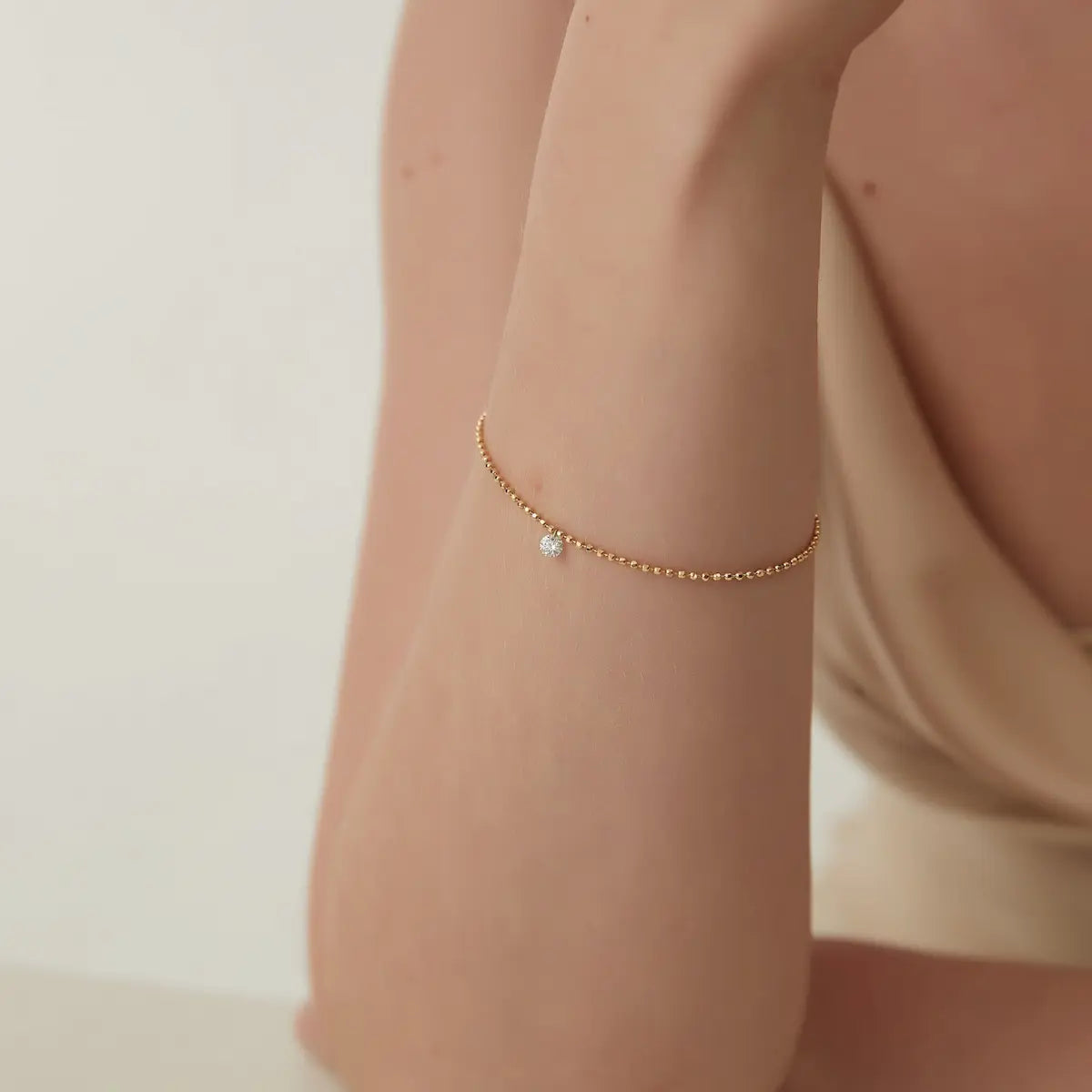 A fashion editorial image featuring a model wearing the Pear Drilled Diamond Bracelet by LTM & CO.™. The photograph captures the piece's cinematic glow against a minimalist background, reflecting its identity as a modern heirloom. It illustrates how the floating 0.2ct pear diamond provides a sophisticated pop of brilliance, highlighting the architectural light philosophy and the high-fashion appeal of the Pure Brilliance collection.