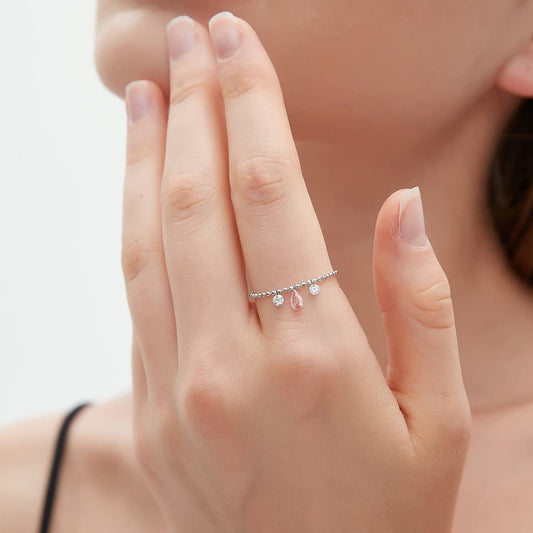 A detailed macro close-up focusing on the master craftsmanship of the Trio Diamond Chain Ring. The photograph reveals the precise settings of the 0.13ct pink pear and dual 0.08ct white round diamonds, showcasing their intense color contrast and brilliance. The high-definition image emphasizes the flexible link structure of the 18K gold chain band and the architectural precision of LTM Jewels. This view is essential for appreciating the quality of the D-E color white stones and the pink pear centerpiece.