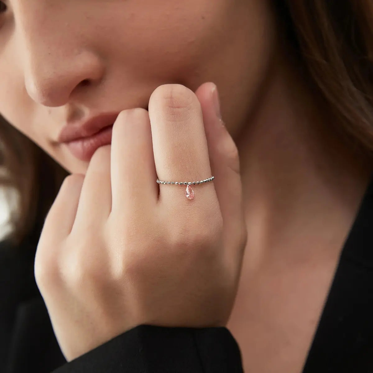 Editorial shot of a model wearing the LTM & CO. Pink Pear Diamond Chain Ring. The minimalist 18K gold and radiant pink lab diamond complement a refined style. Represents sustainable luxury and the brand's unique architectural aesthetic for the modern, conscious consumer.