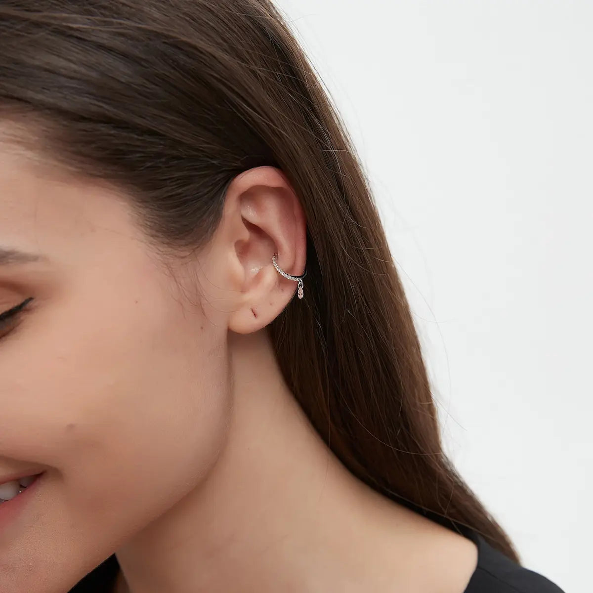 Macro close-up of the Pink Pear Diamond Ear Cuff handcrafted in solid 18K gold. The floating pink pear-cut diamond and white diamond accents create uninterrupted brilliance, soft romantic glow, and refined architectural craftsmanship inspired by editorial fine jewelry.