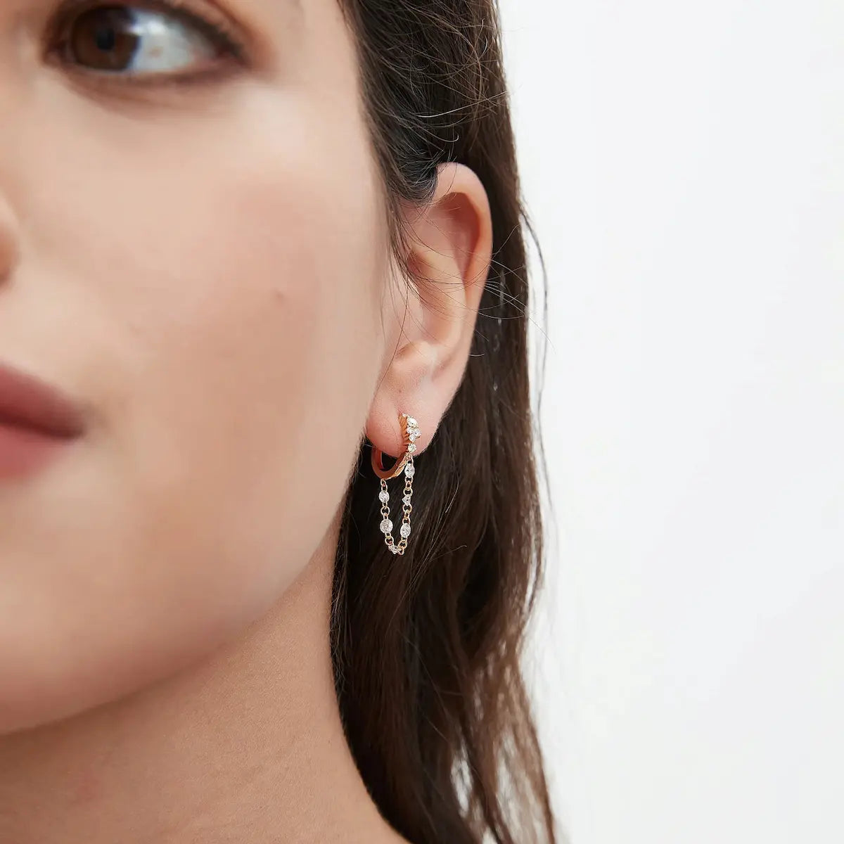Lifestyle photography of a model wearing the LTM Jewels Radiant Cascade diamond hoop, showcasing its elegant motion and luxurious sparkle in natural light. The aesthetic captures the "soft glamour" theme, highlighting the earring as a statement piece for both casual elegance and evening events. This shot emphasizes the scale of the 0.50ctw diamond arrangement, proving it as a hypoallergenic, shower-safe investment piece that complements a modern, ethically-conscious lifestyle.