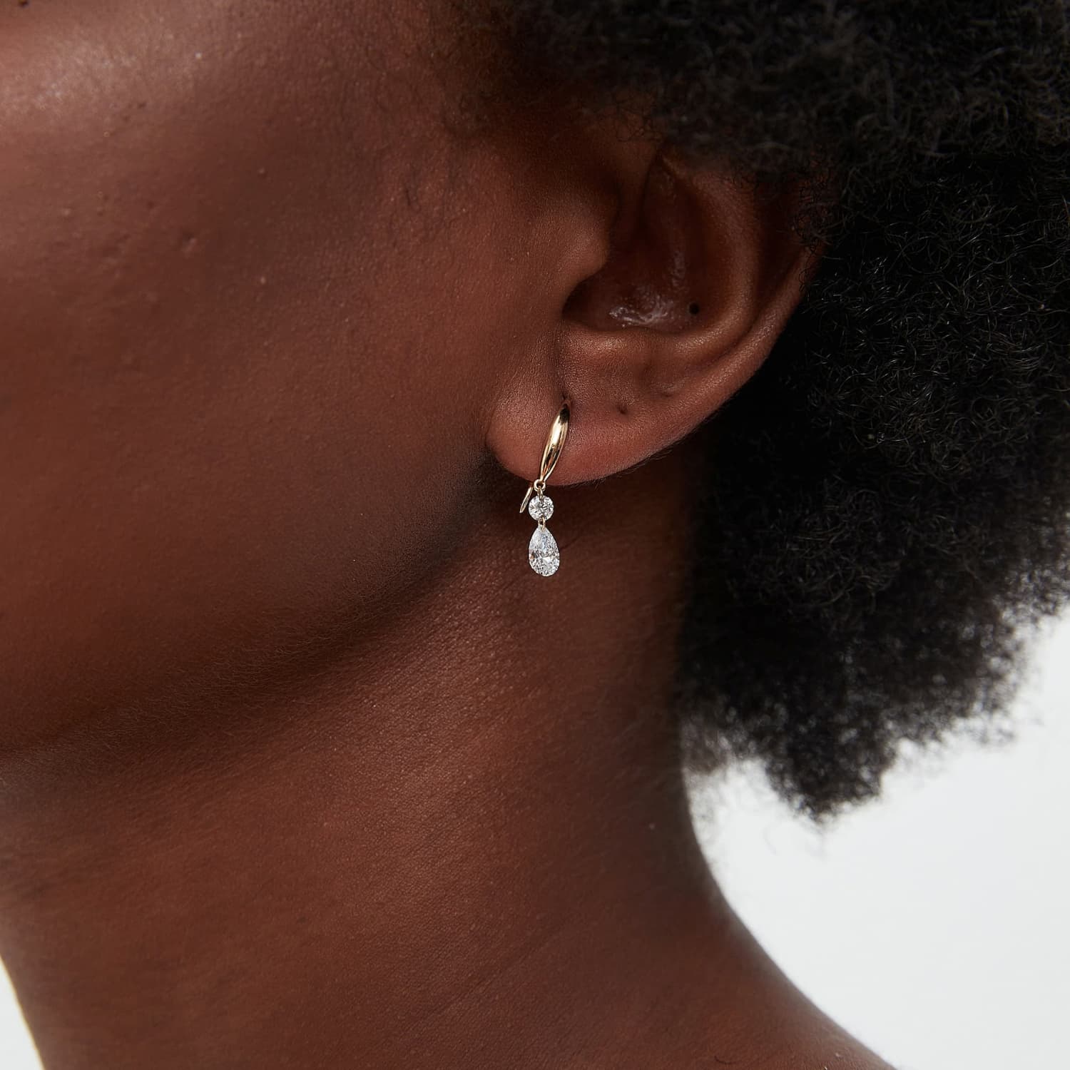 A technical side profile view showing the structural integrity of the 18K solid gold dangle and the threaded screw back closure, designed for a secure 24/7 permanent fit.