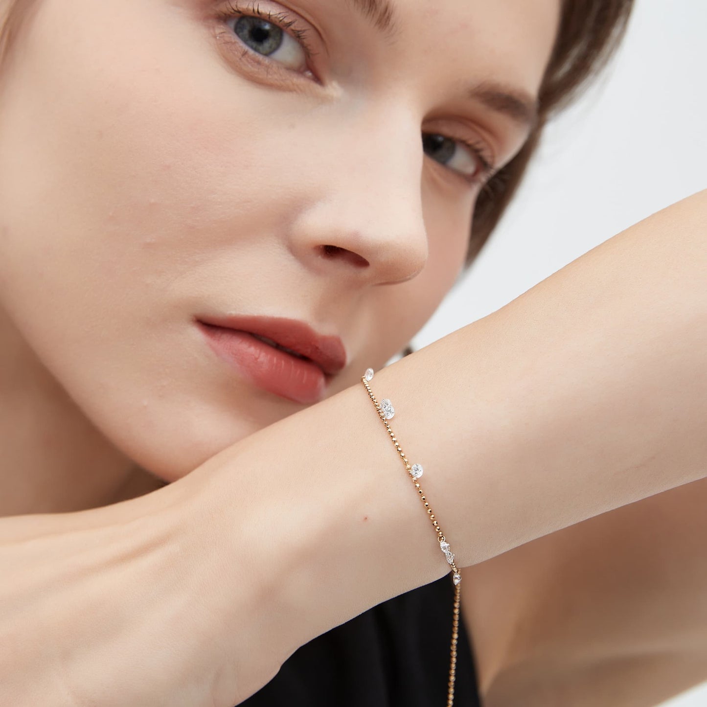 Minimalist 18K gold multi-diamond bracelet styled on a woman's wrist.