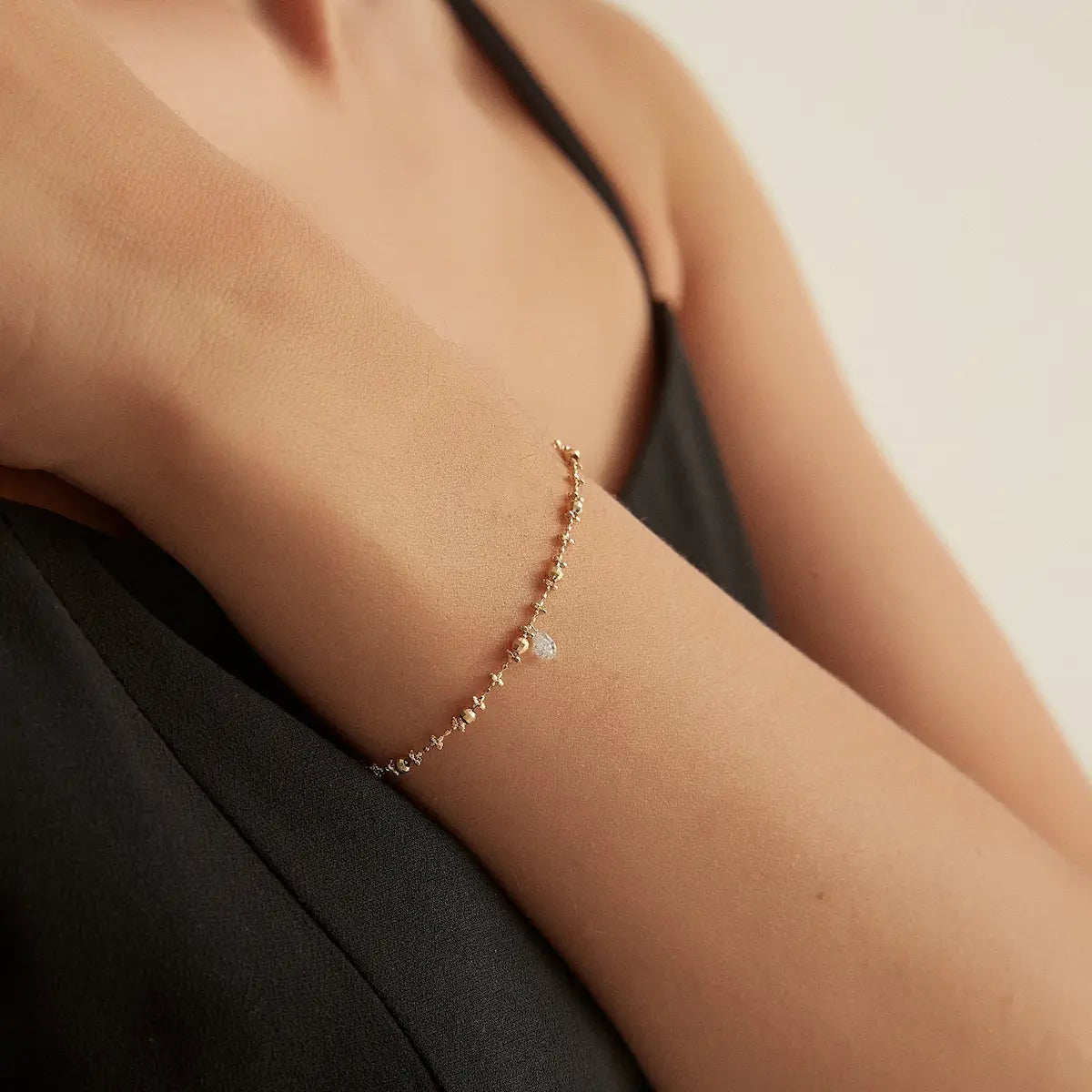 Side view of the Floating Pear Diamond Bracelet highlighting the signature laser-drilled floating diamond setting, polished 18K solid gold bead chain, and adjustable sliding silicone clasp. The modern construction allows the pear-cut diamond to appear weightless while maximizing brilliance.