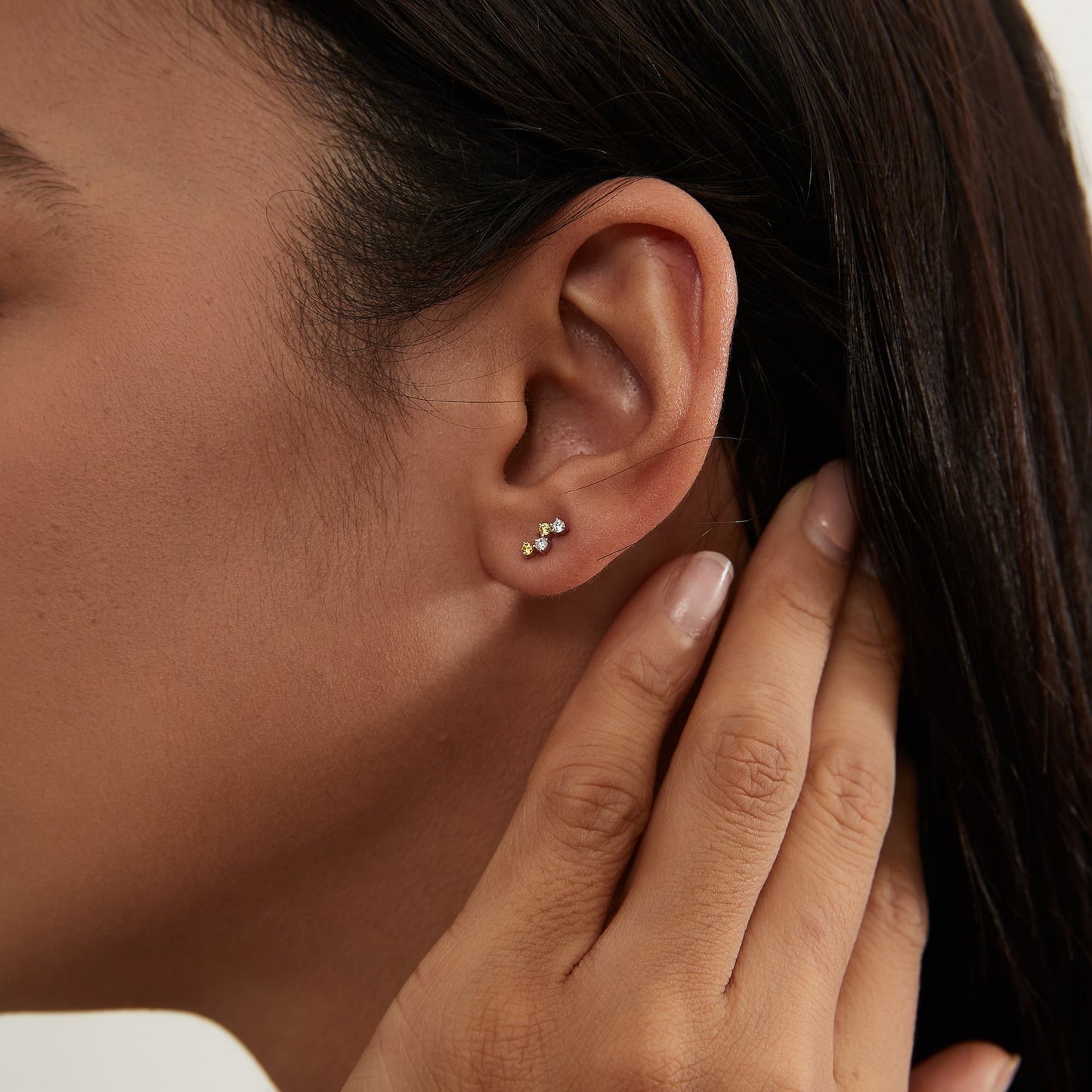 Model wearing The Solar yellow diamond threaded stud in a curated ear piercing stack