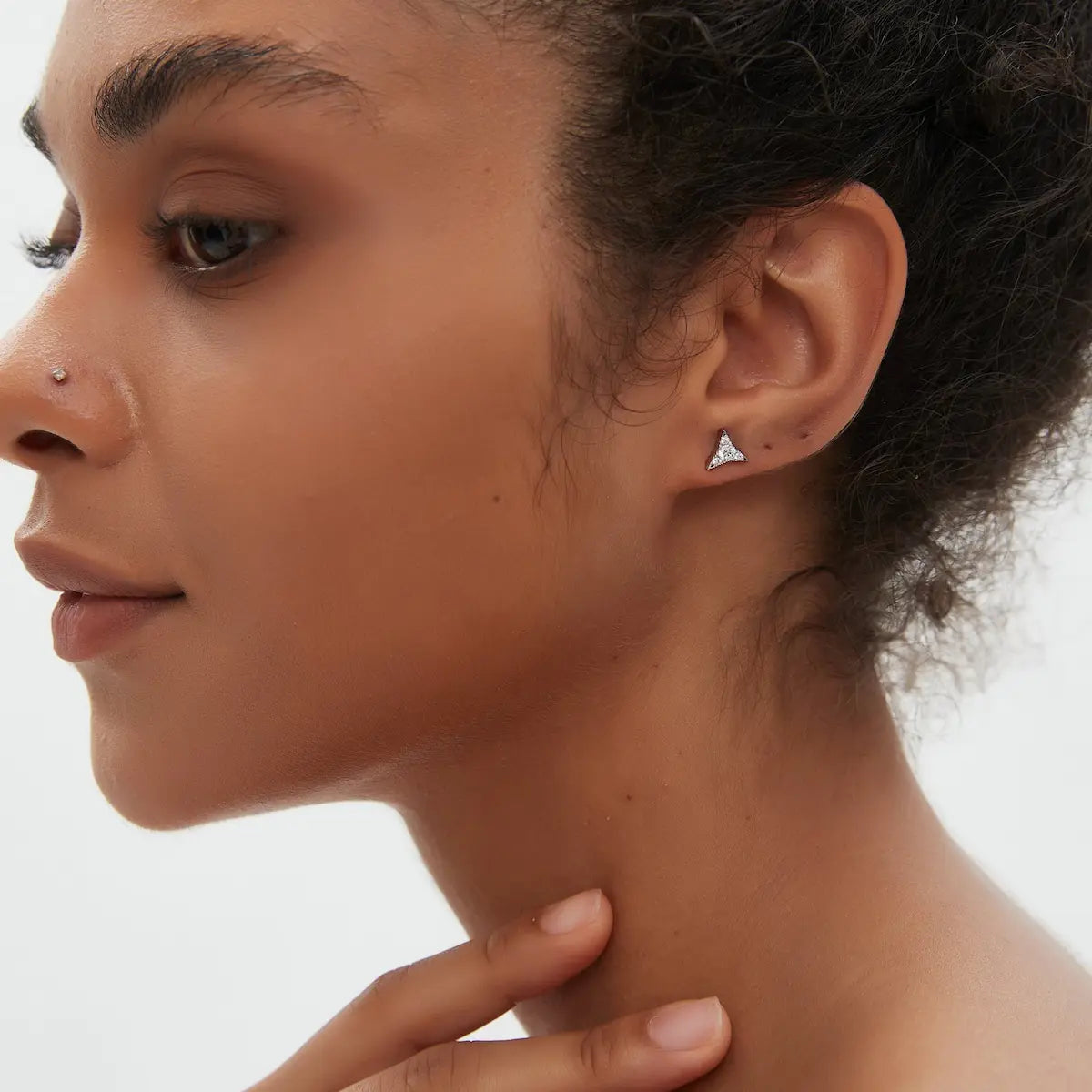 Diamond Star Stud worn on the ear featuring natural round diamonds arranged within a sculptural geometric star silhouette crafted in solid 18K gold. The lightweight celestial structure creates modern curated ear styling and refined minimalist luxury.
